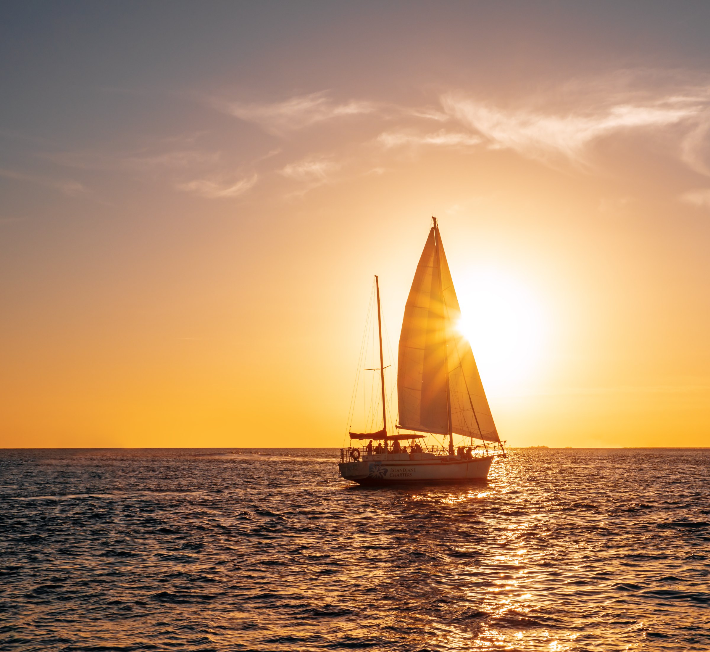 Segelboot auf dem Meer im Gegenlicht der untergehenden Sonne